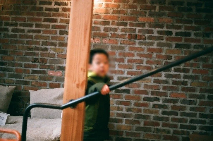 벽돌 벽 실내 계단 난간 옆의 아이