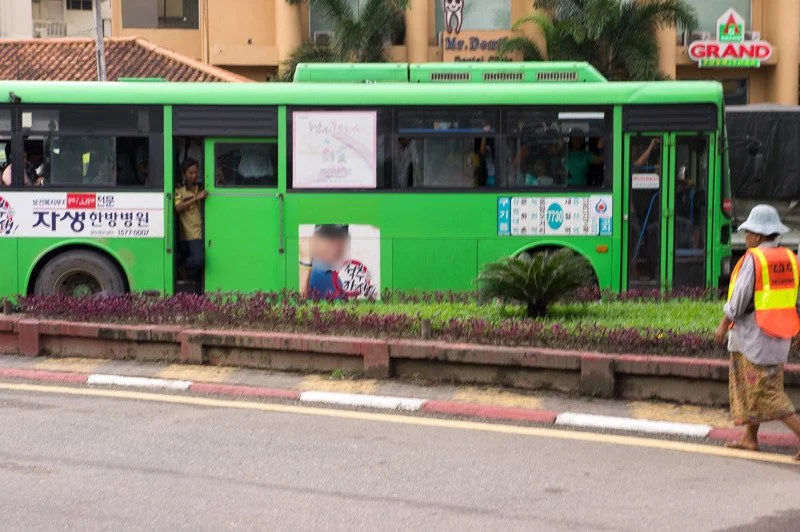 한글 광고가 붙은 초록색 버스