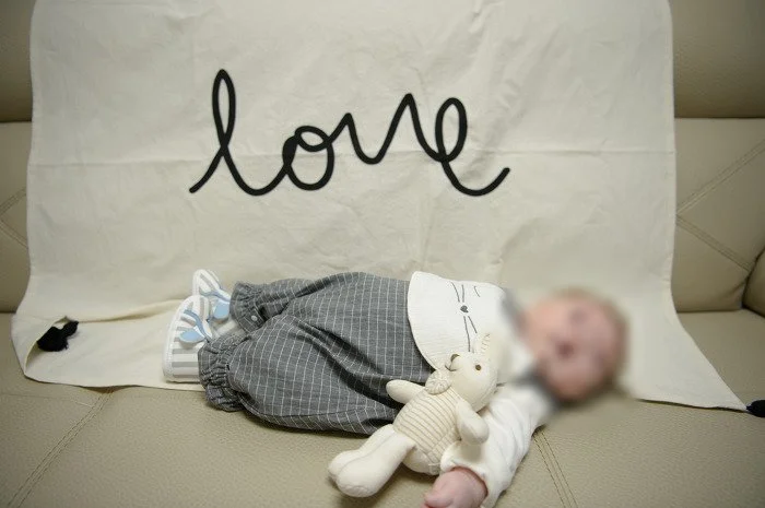love 글씨 천 위에 토끼 인형과 누운 아기