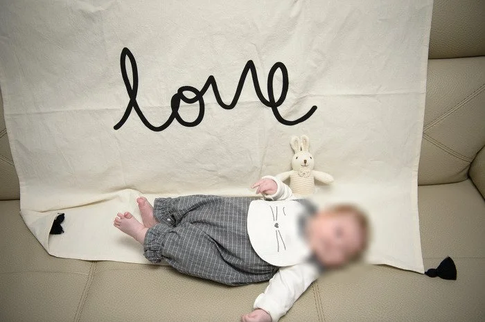love 글씨 천 위에 토끼 인형과 누운 아기
