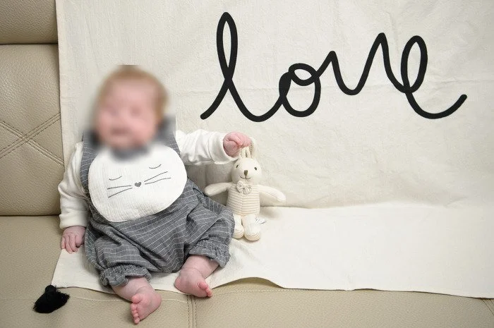 love 글씨 천 앞에 앉은 아기와 토끼 인형