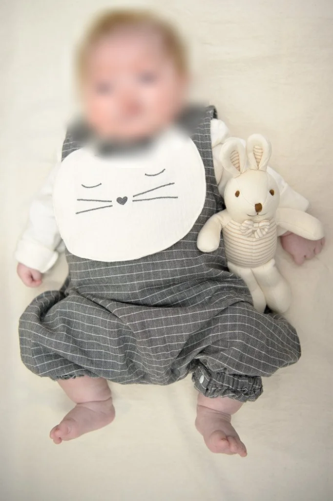 세로로 담은 토끼 인형 옆에 누운 아기