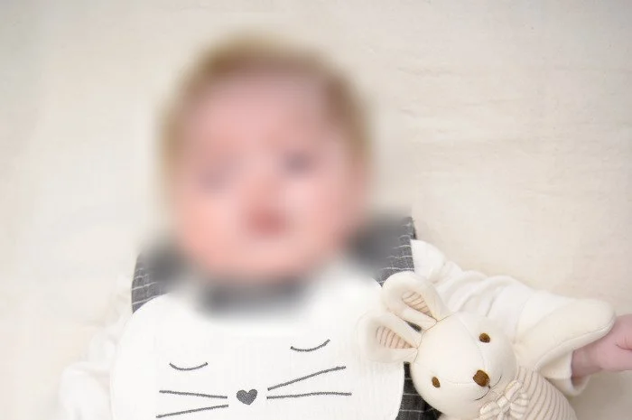 가까이서 담은 토끼 인형 옆 아기의 얼굴