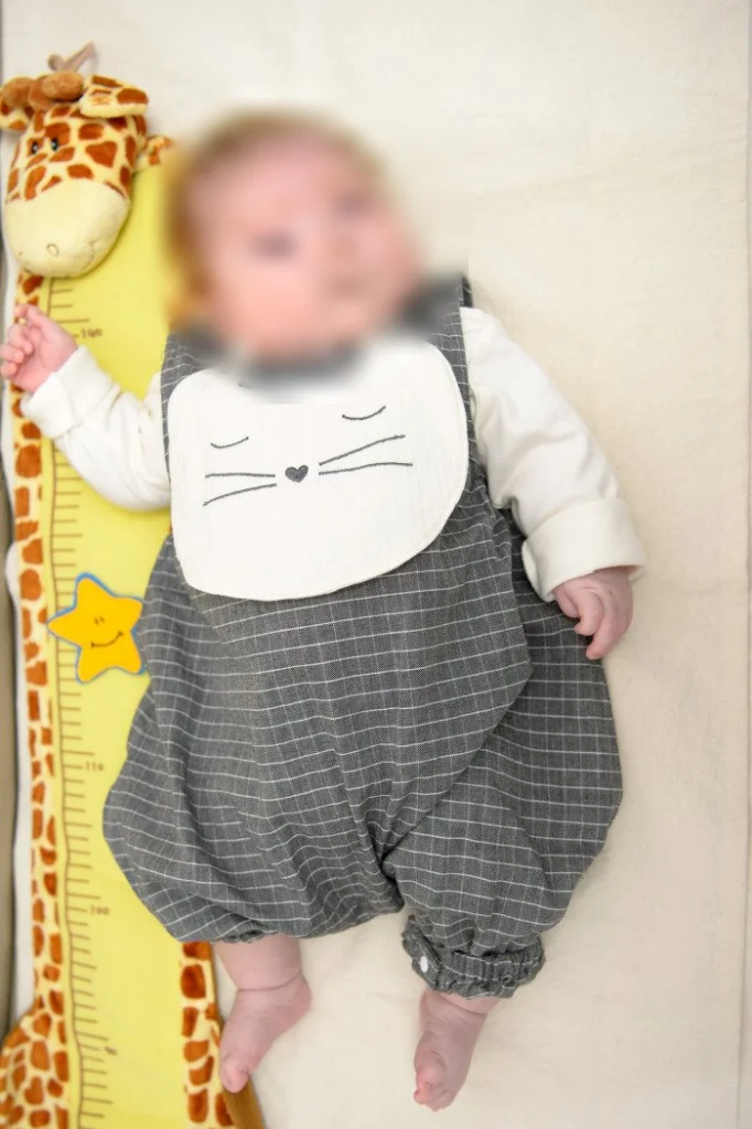 기린 키재기 옆에 누운 아기