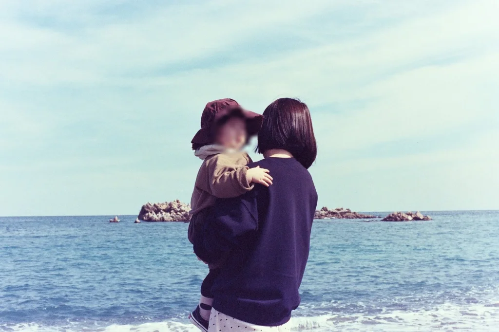 바다를 등지고 안겨 있는 아들