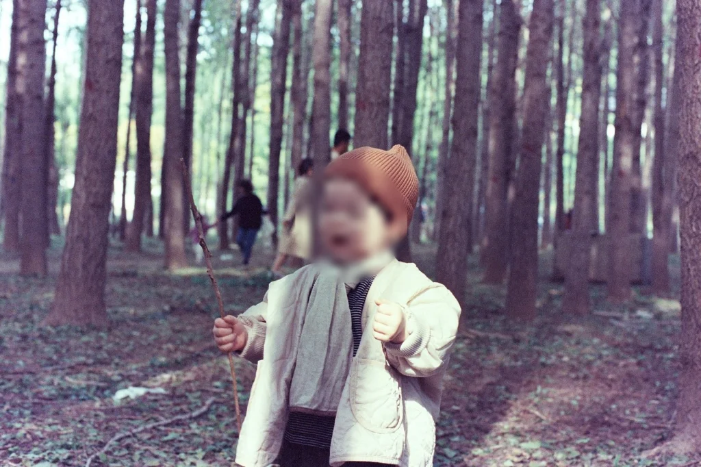 숲 속에서 막대기를 든 아들