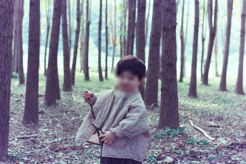 모자를 벗고 막대기를 쥔 아들