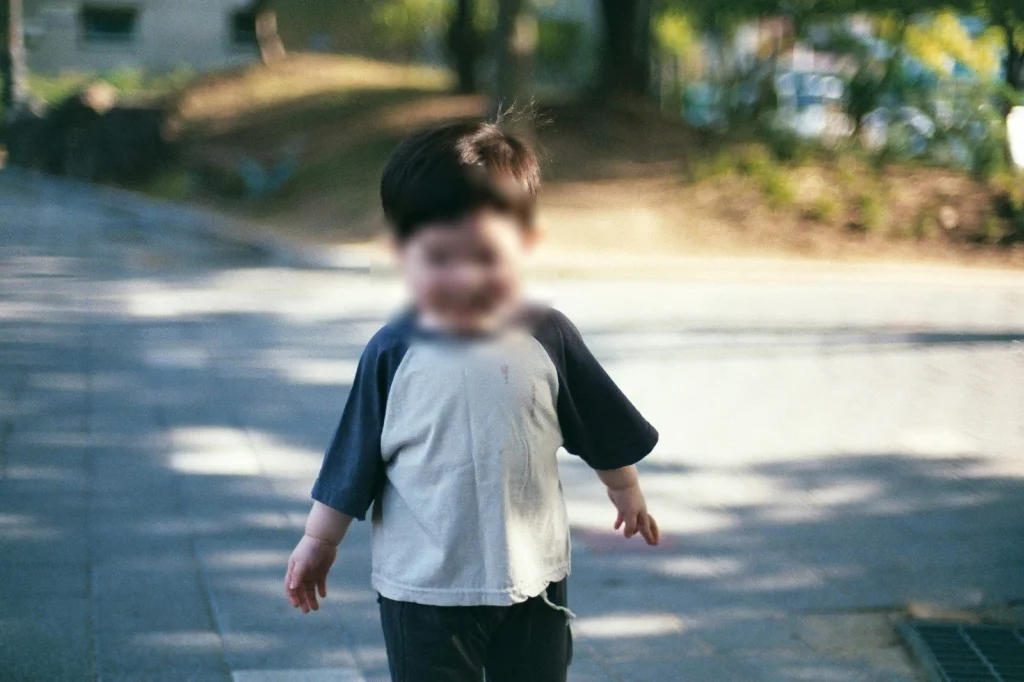 햇빛 드는 보도블록 길을 걸어오는 아들
