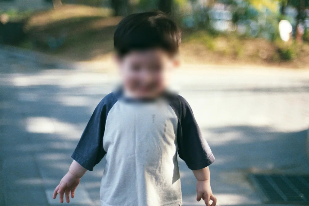 햇빛 드는 보도블록 길을 걸어오는 아들