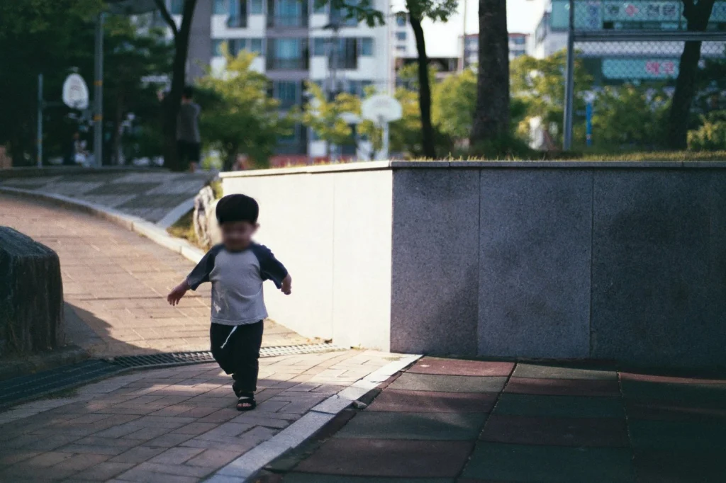 낮은 돌벽 앞 경사로를 걷는 아들