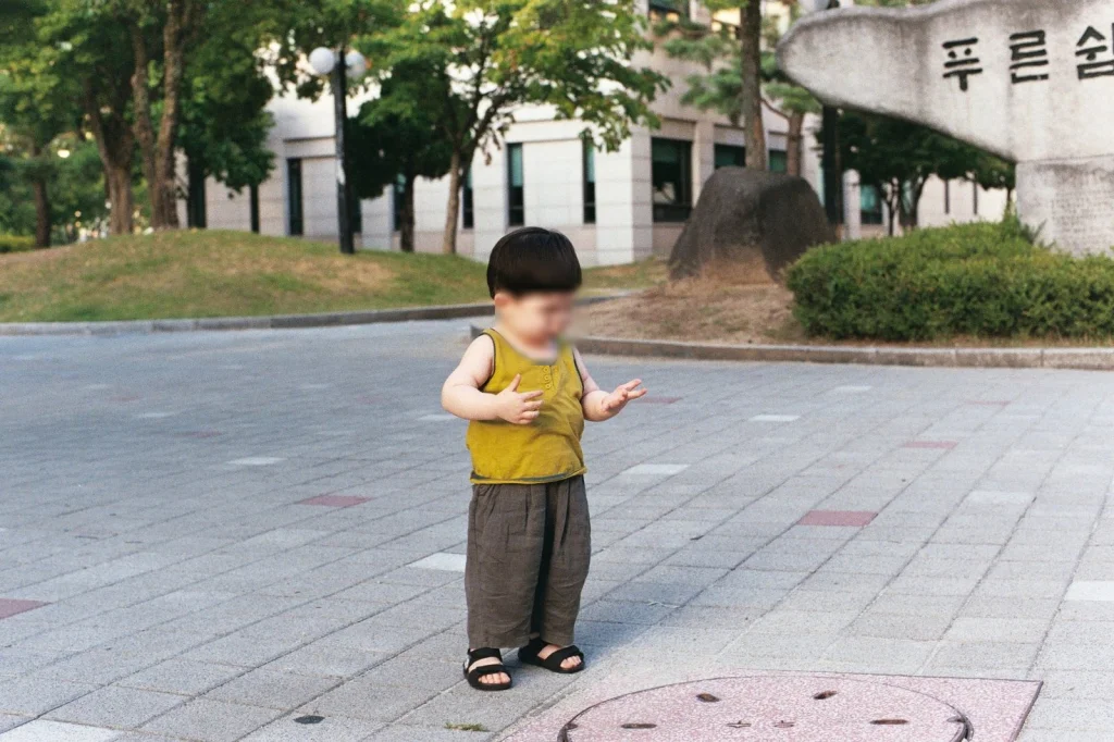 푸른숲 표지석 앞 광장에 선 아들