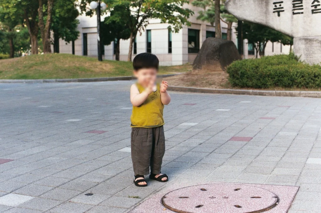 푸른숲 표지석 앞 광장에 선 아들