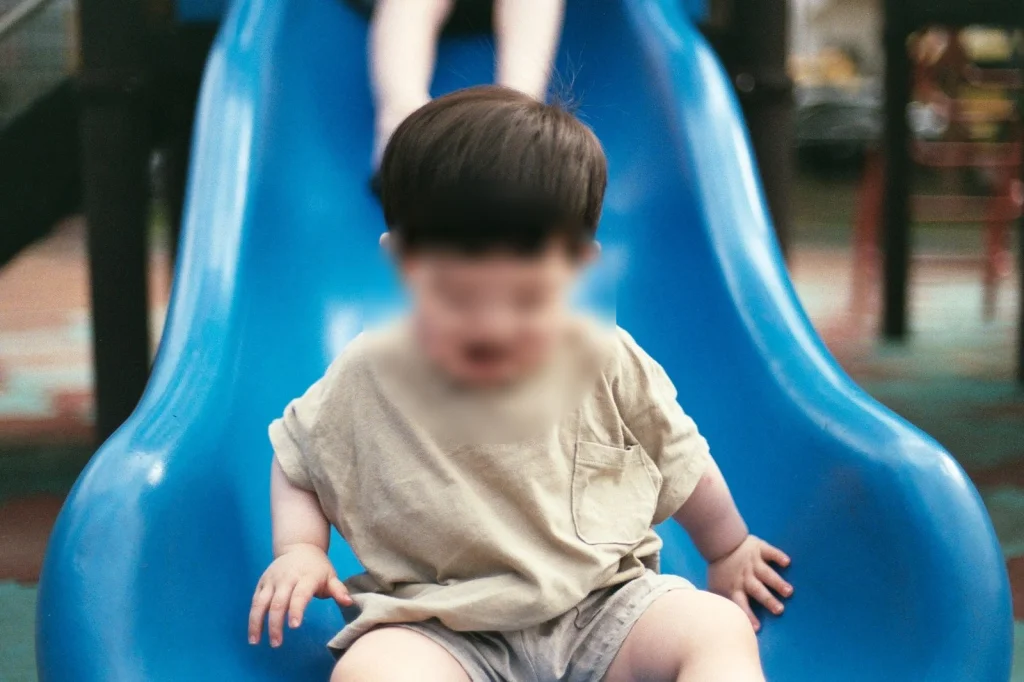파란 미끄럼틀을 타고 내려오는 아들