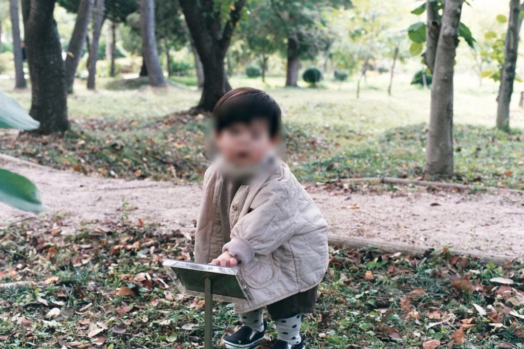숲길 안내판 앞에 쪼그려 앉은 아들