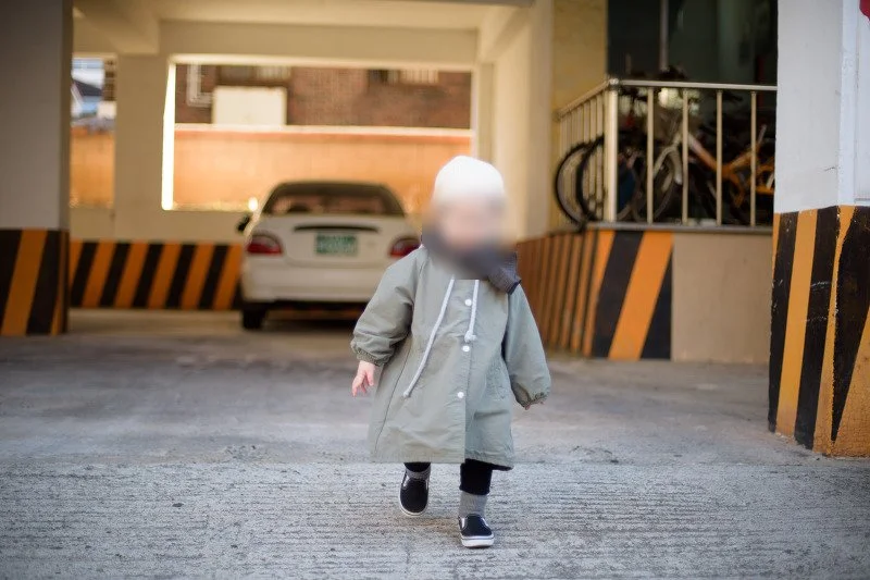 주차장 기둥 사이를 걸어 나오는 아들