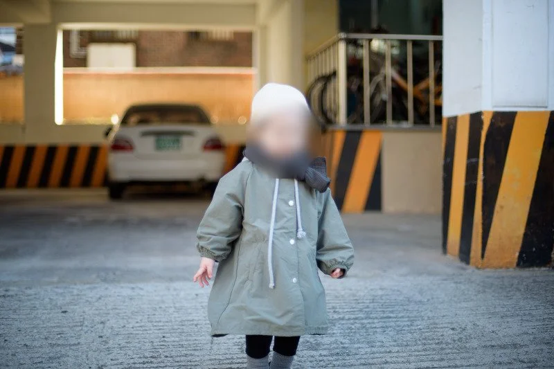 주차장 기둥 사이를 걸어 나오는 아들