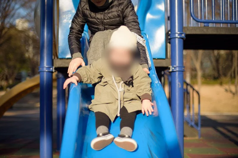 파란 미끄럼틀을 타고 내려오는 아들