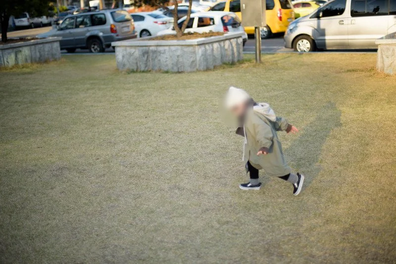 넓은 잔디밭을 가로질러 달리는 아들