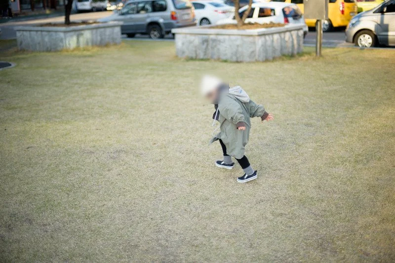넓은 잔디밭을 가로질러 달리는 아들