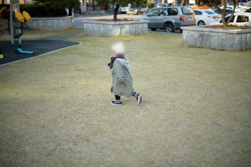 넓은 잔디밭을 가로질러 달리는 아들