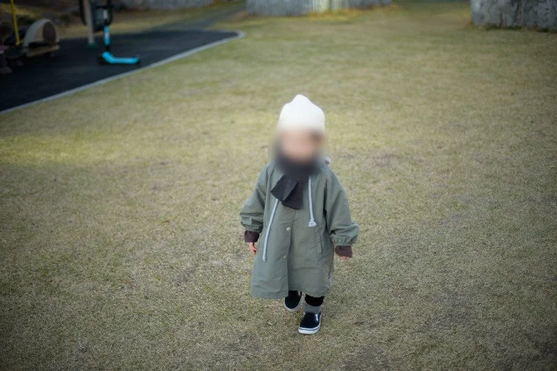 잔디밭에서 카메라 쪽으로 걸어오는 아들