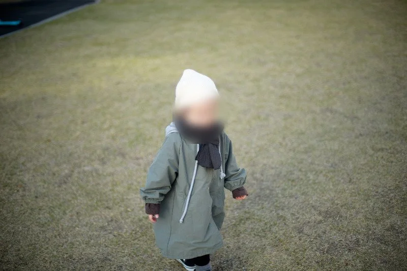 잔디밭에서 카메라 쪽으로 걸어오는 아들