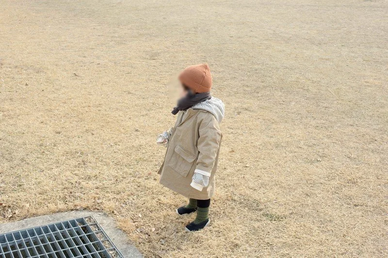 마른 잔디밭 위에 선 아들