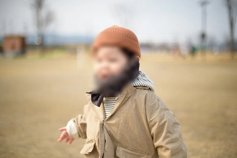 목도리를 두르고 잔디밭을 달리며 웃는 아들