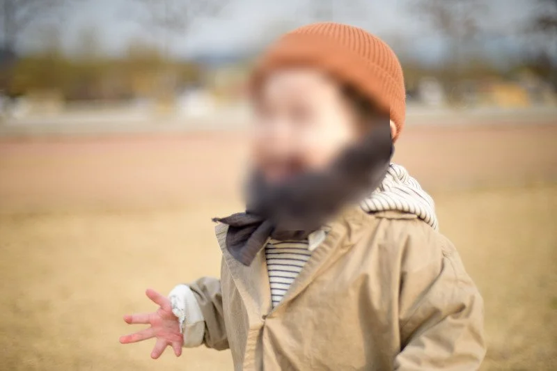 목도리를 두르고 잔디밭을 달리며 웃는 아들