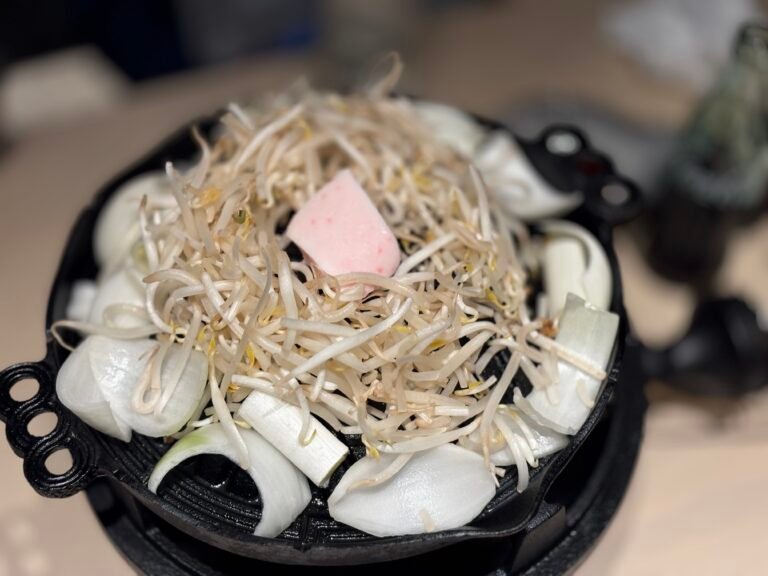검은 철판 위에 가는 채소와 양파가 올라간 상차림