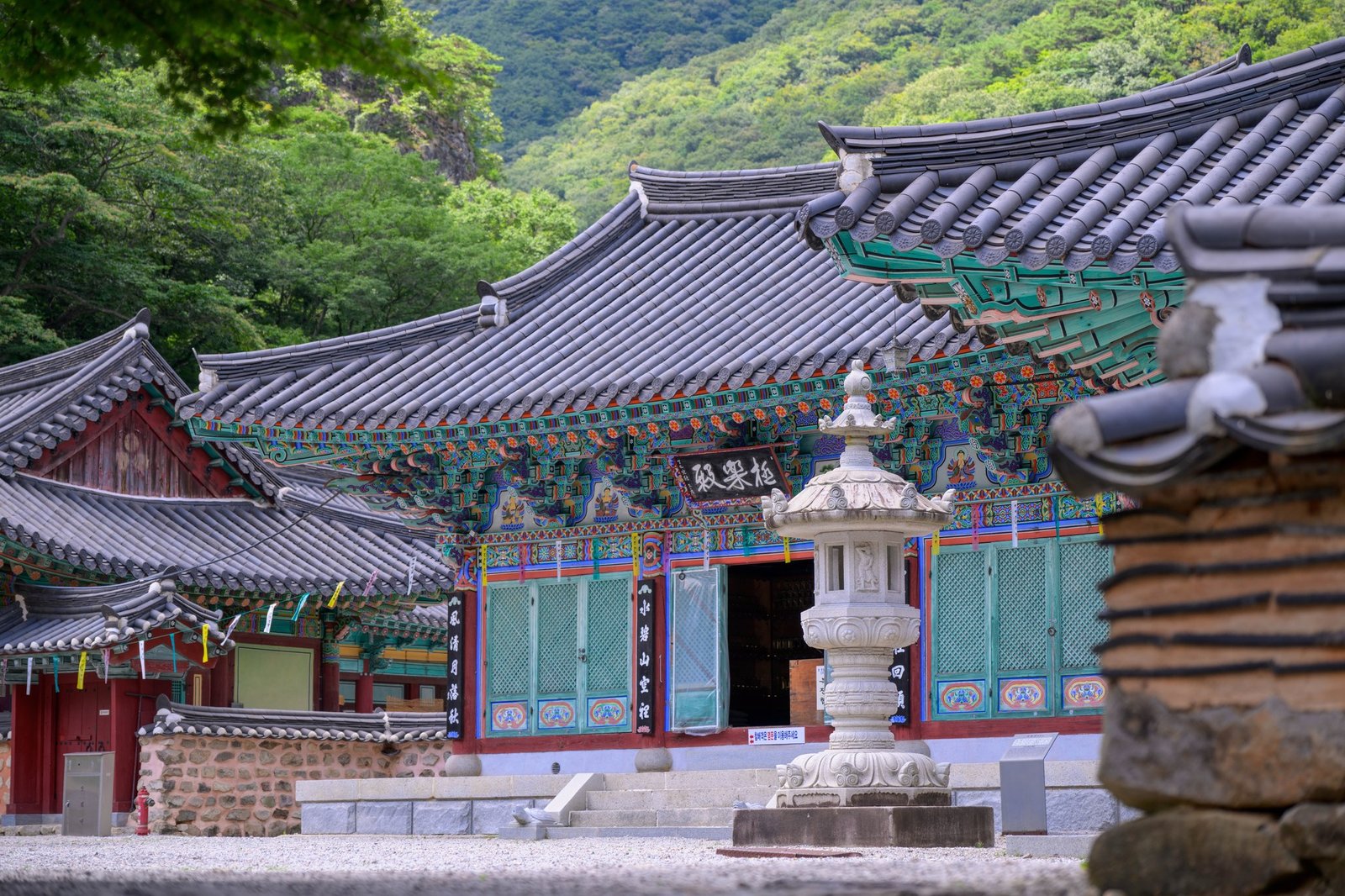 순창 내장사 극락전 정면, 여름 산을 배경으로 한 단청과 석등