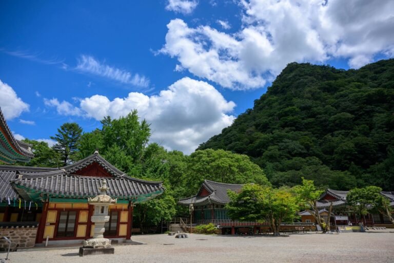 파란 하늘과 구름 아래 내장사 마당과 석등, 뒤로 산