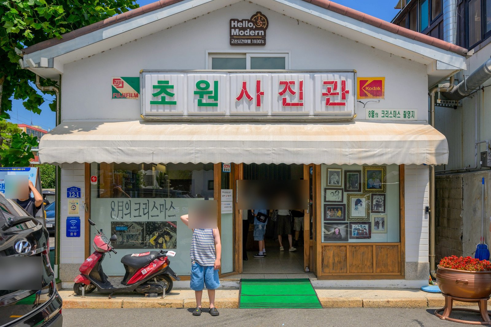 군산 초원사진관 간판 아래 서 있는 아이(얼굴 블러 처리)