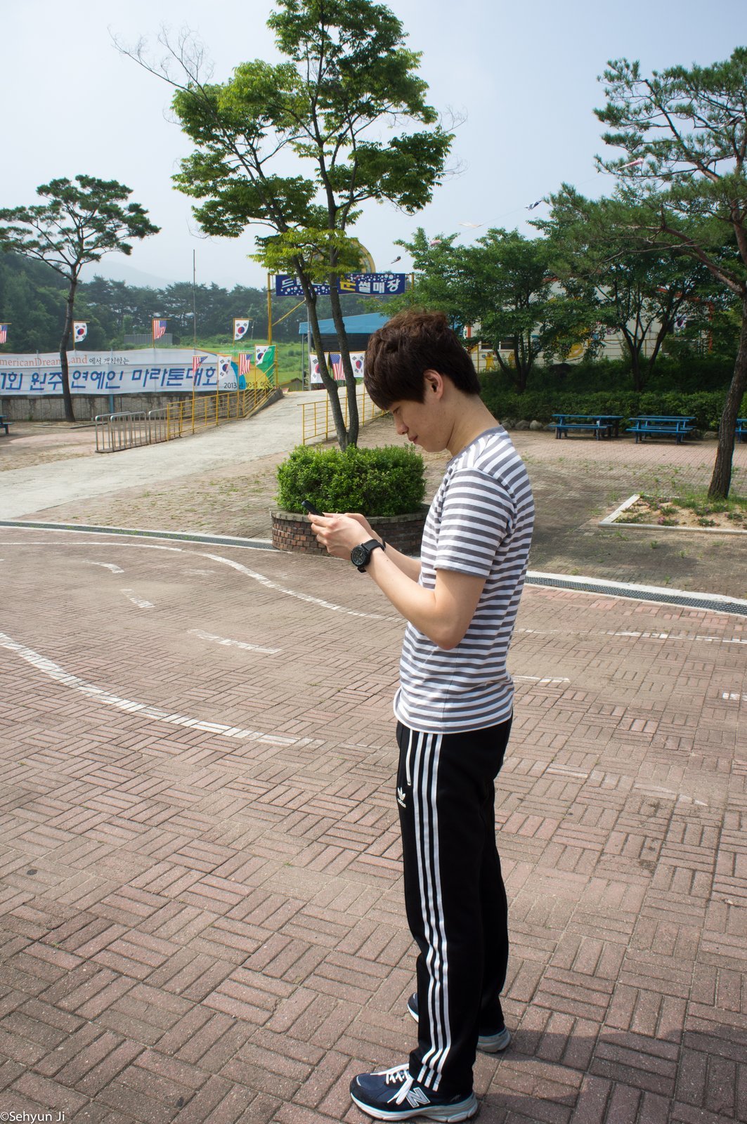 휴대폰을 확인하며 서 있는 모습