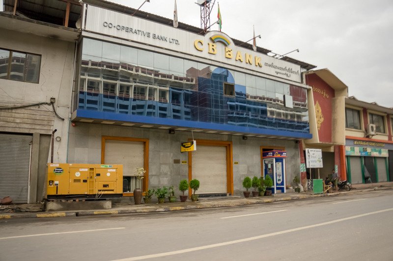 CO-OPERATIVE BANK LTD. 간판이 붙은 건물 앞에 놓인 노란 발전기
