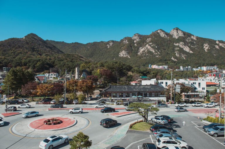 높은 곳에서 내려다본 붉은색 로터리와 주차장, 뒤쪽에 바위가 드러난 산 능선