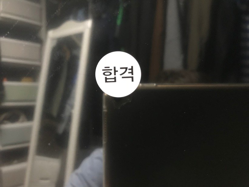 TV 화면 쪽에 붙은 합격 스티커