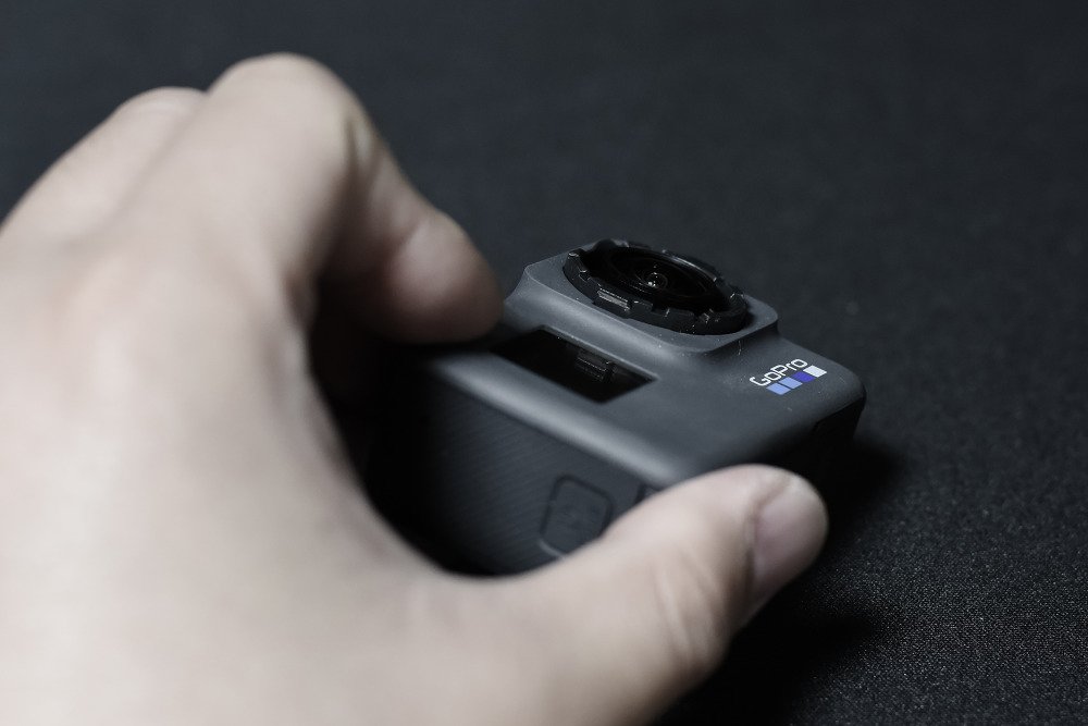 렌즈캡을 뺀 카메라를 비스듬히 찍은 모습, 옆면에 GoPro 글자가 있다