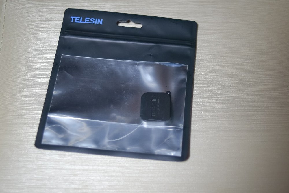 TELESIN 표기가 있는 지퍼백에 담긴 작은 검은 렌즈캡