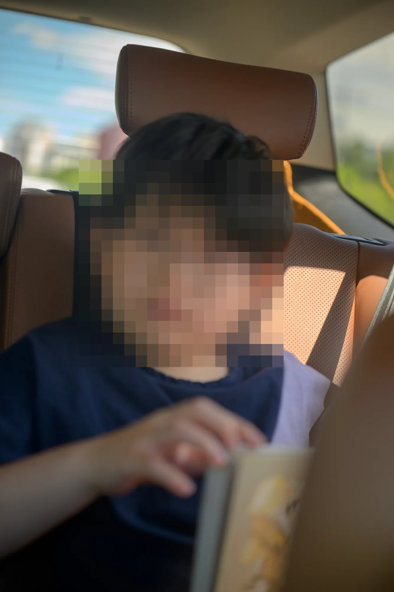 뒷좌석에서 책을 읽는 아들