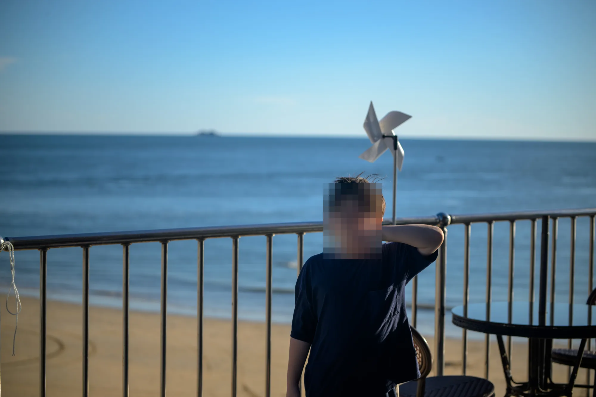 짚라인 아래 1층 카페 테라스, 바람개비와 난간 너머 대천해수욕장