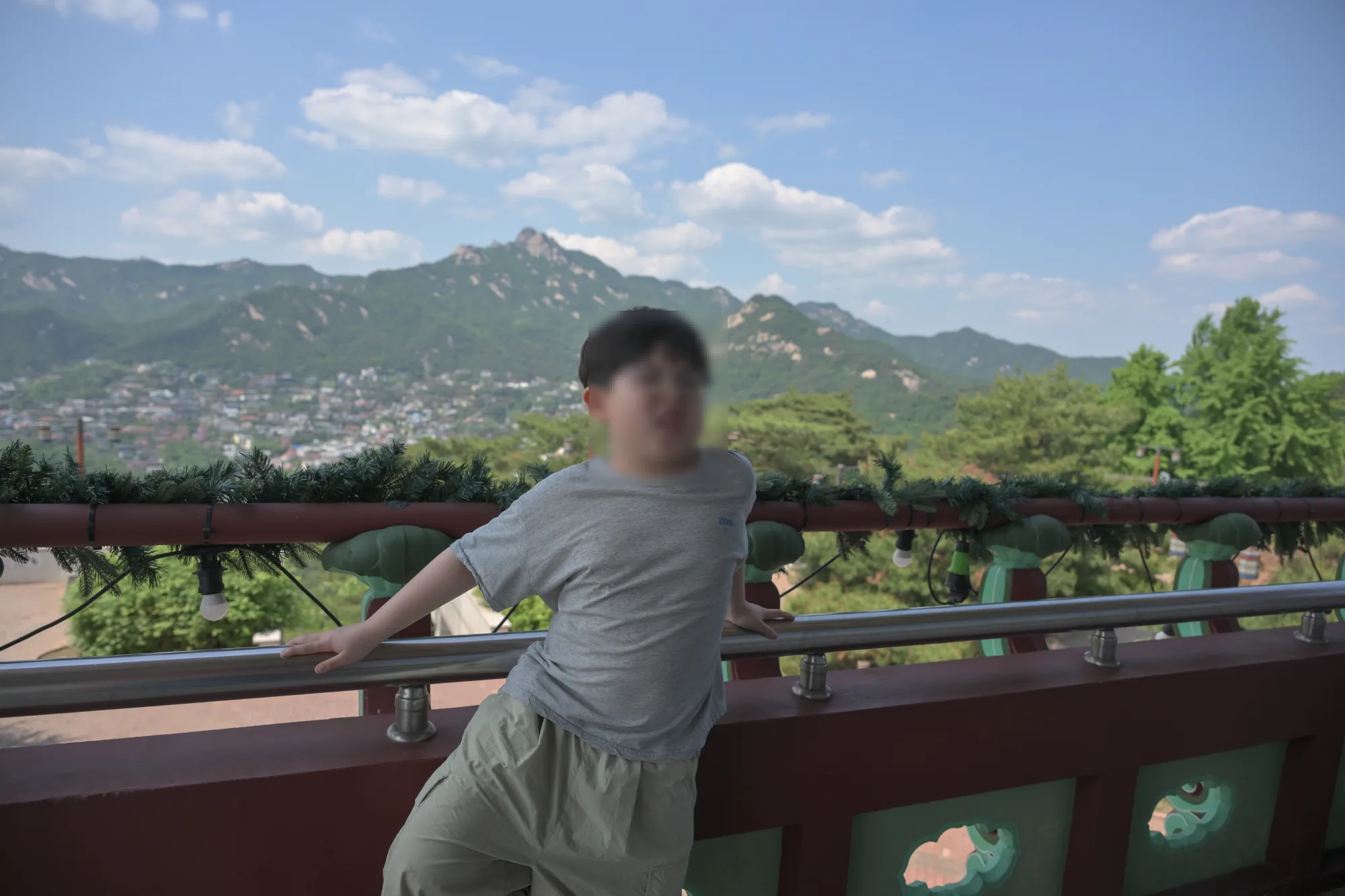 북악스카이웨이 전망대 난간에 기대 선 아이, 뒤로 산과 도심이 보인다