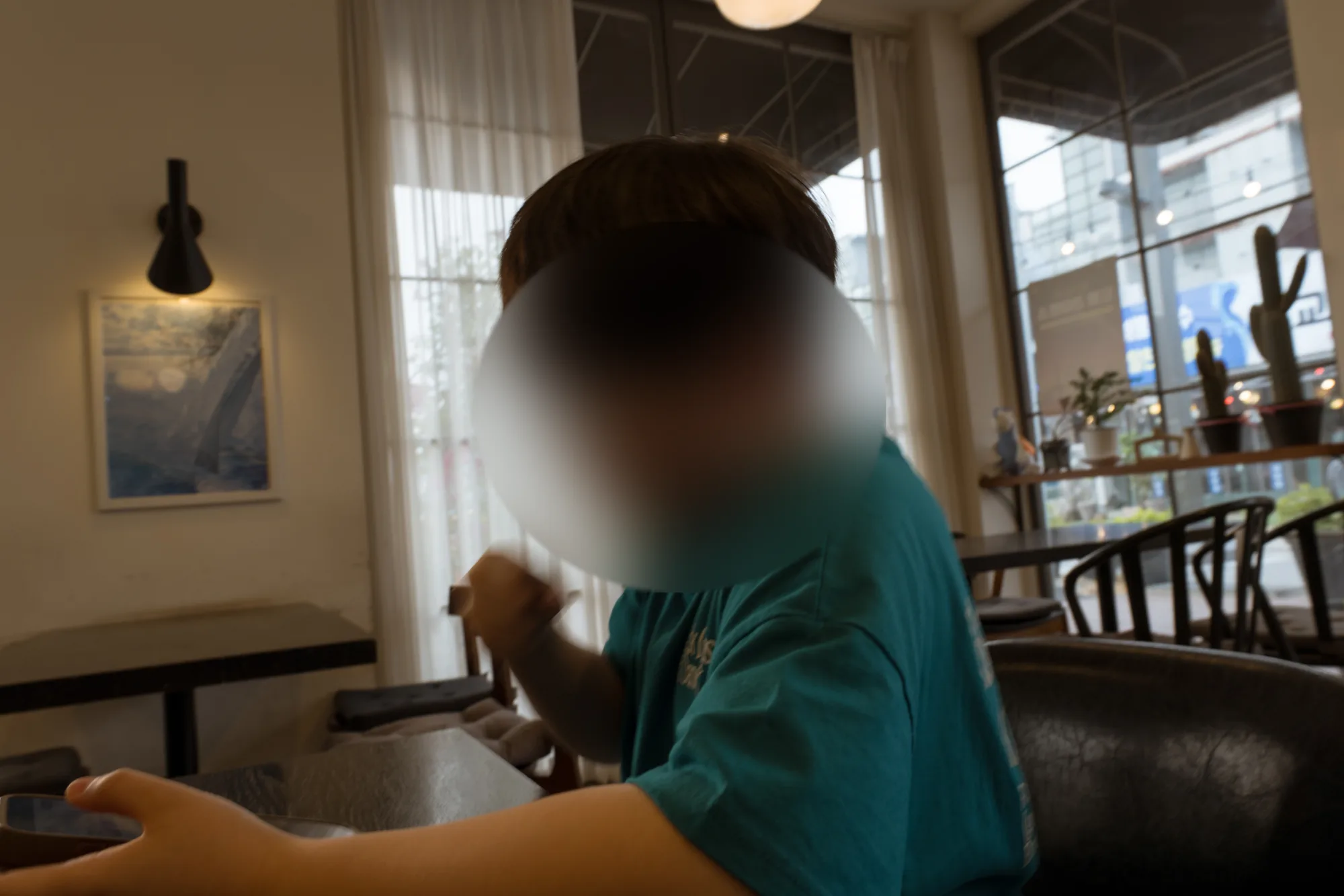 카페 창가 자리에서 숟가락을 든 아들