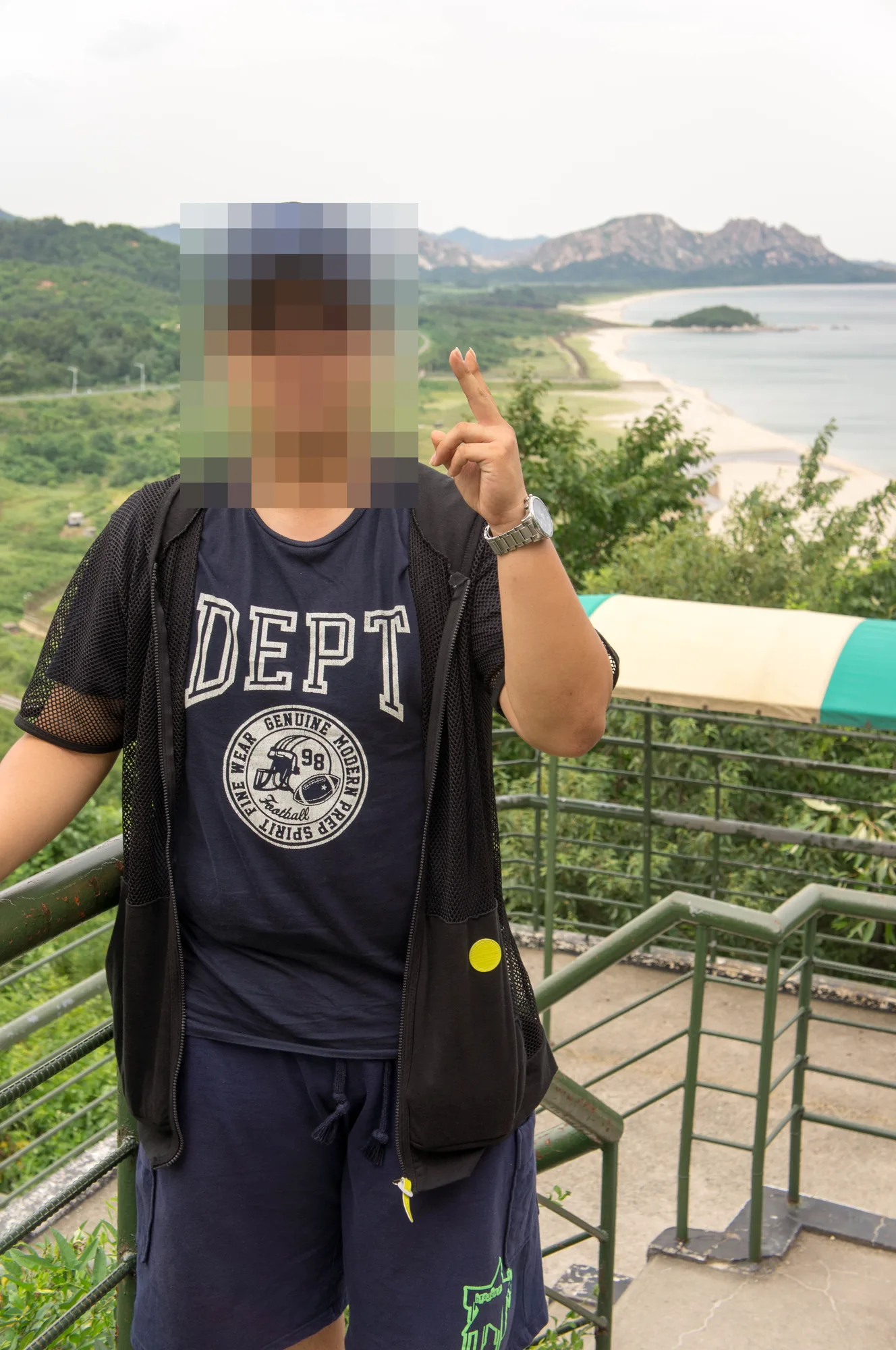 난간에서 바다를 가리키는 친구