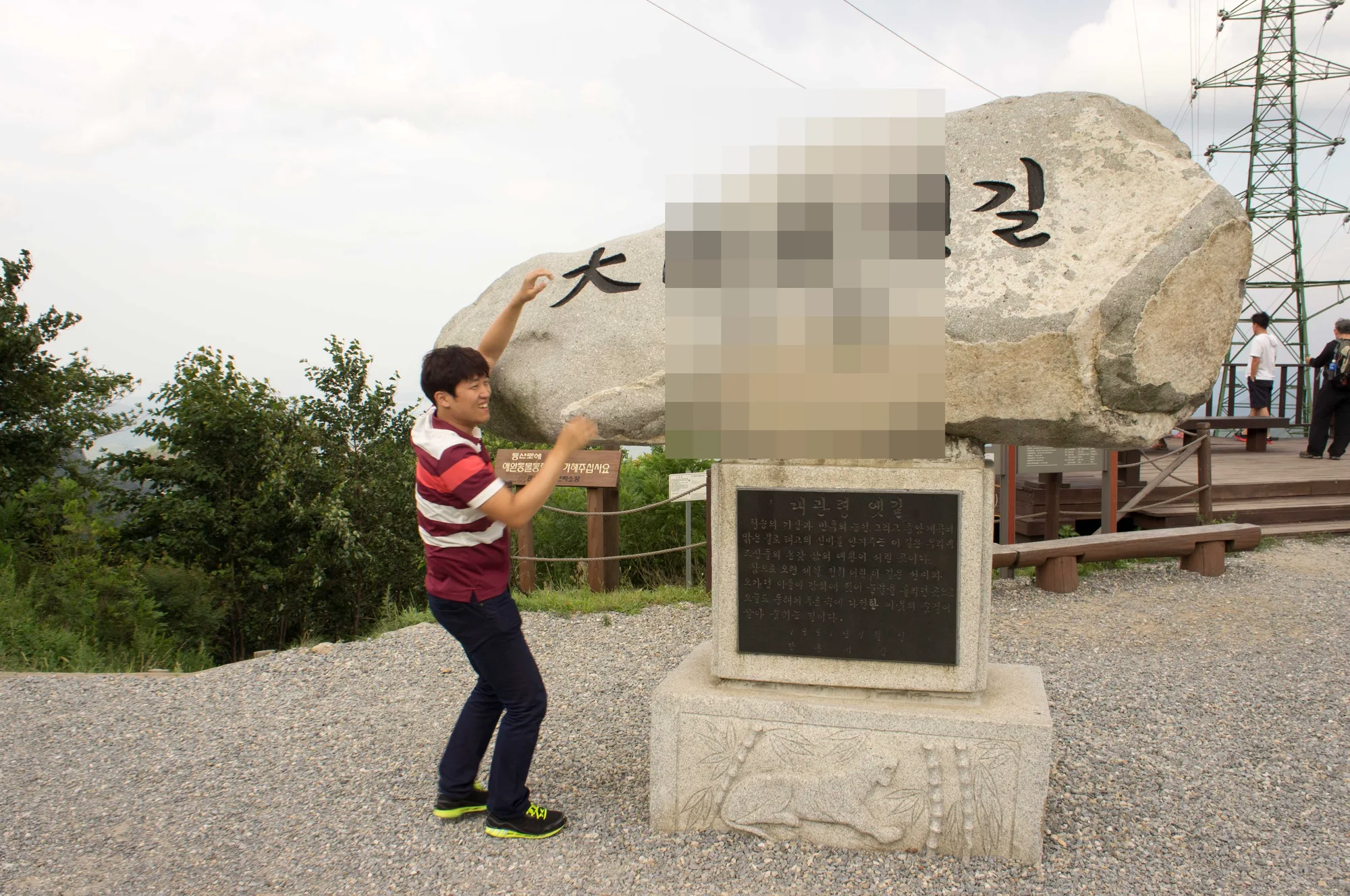 표지석을 떠받치는 시늉을 하는 친구