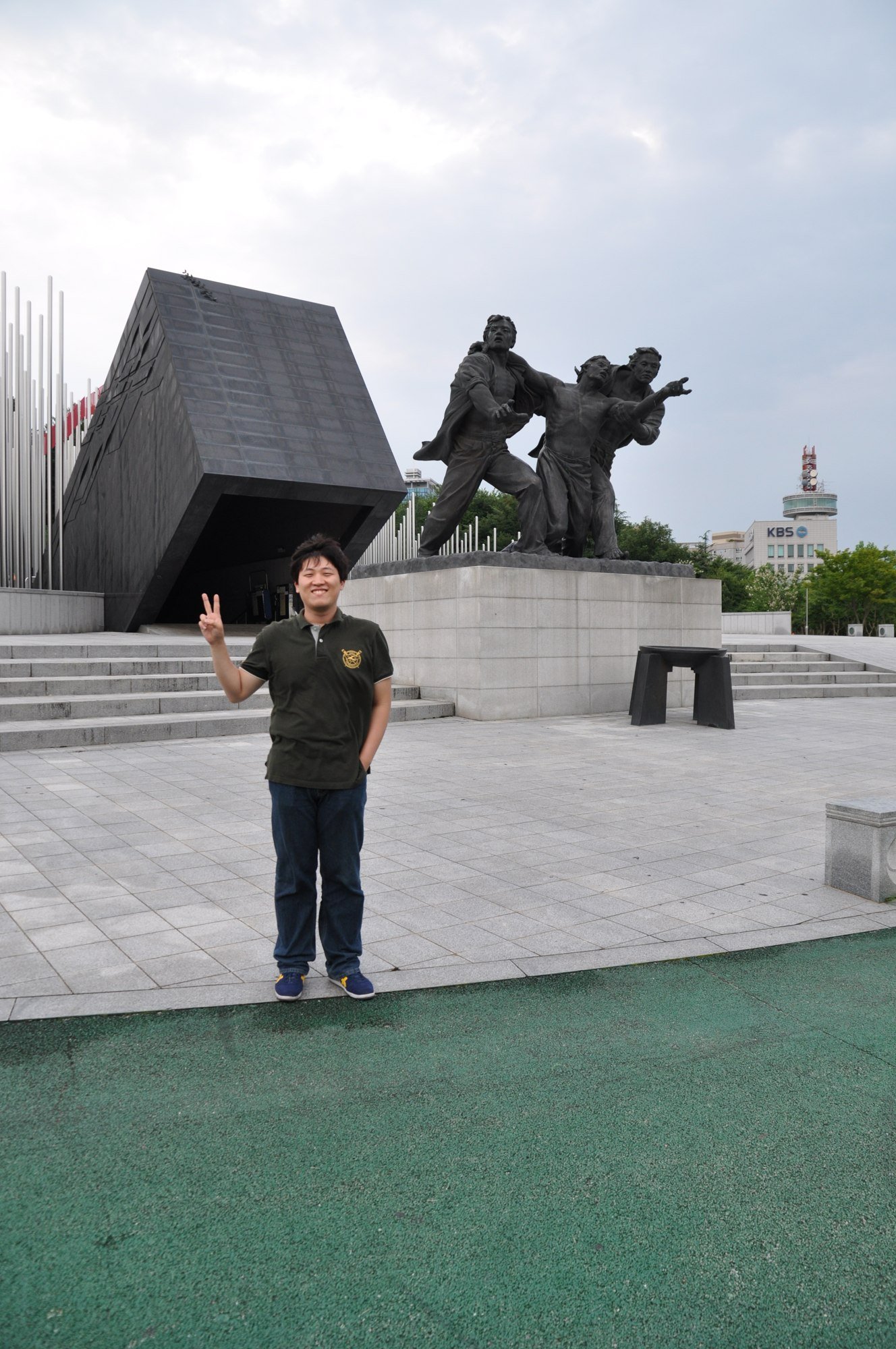 해 질 무렵 청동 조형물 앞에 선 모습