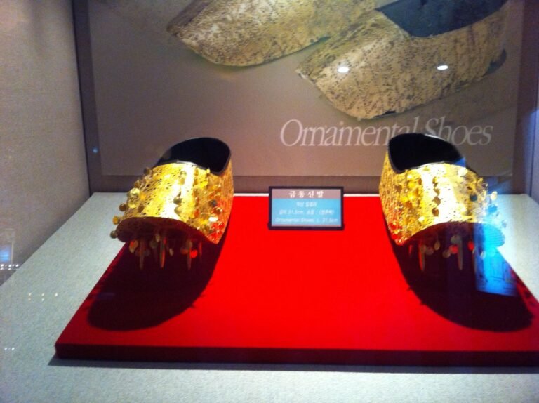 붉은 천 위에 금동신발 한 켤레가 놓인 'Ornamental Shoes' 진열장