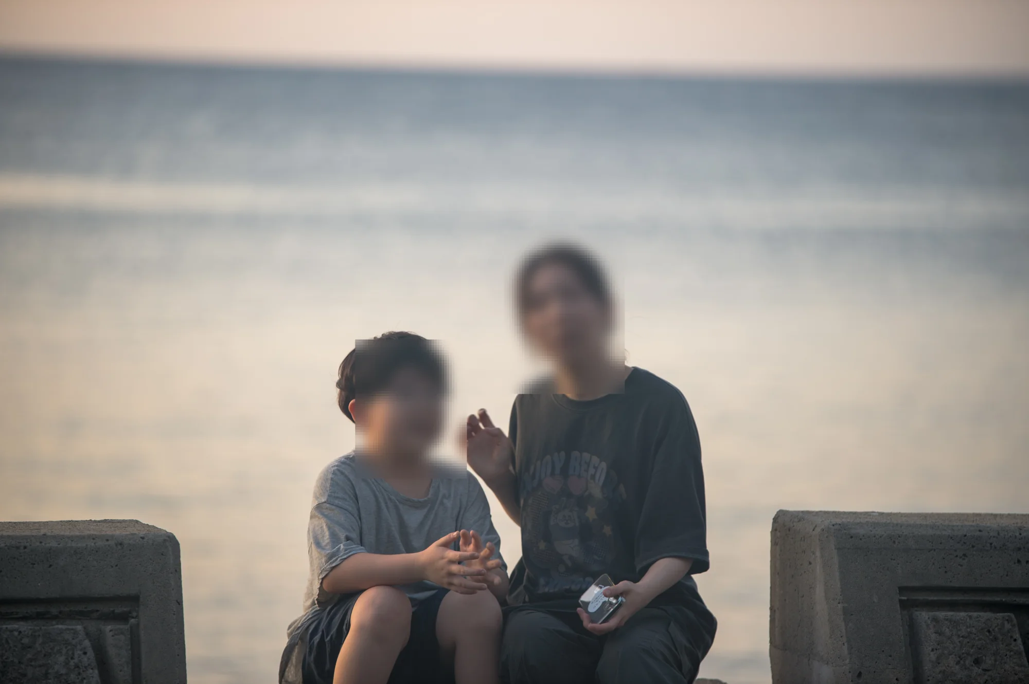 방파제에 나란히 앉은 아내와 아들