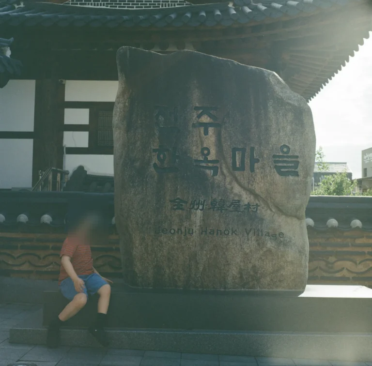 전주한옥마을 표지석 앞에 걸터앉은 아들