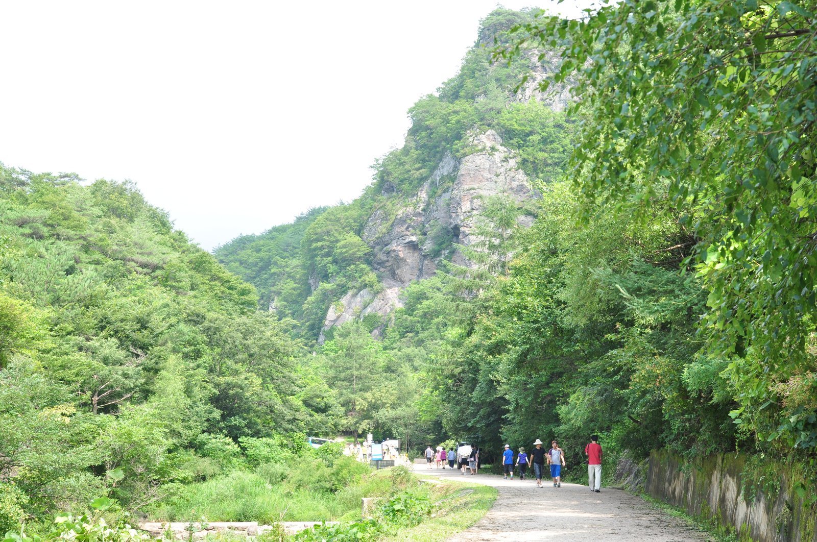양산을 쓴 사람들과 회백색 바위 절벽 산길
